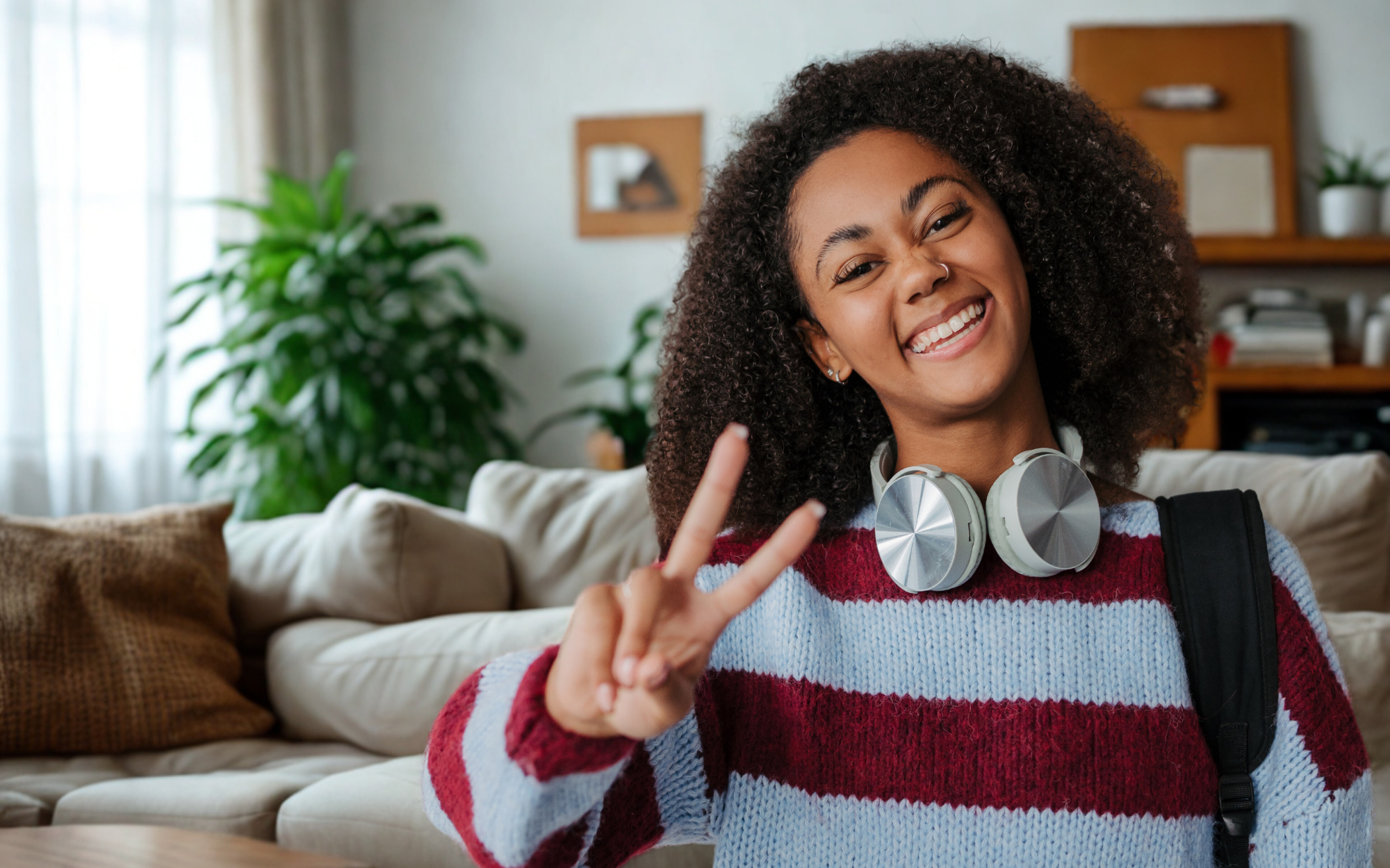 Minnesota high school student smiling at home with headphones and backpack, representing flexible K-12 online learning through Falcon View Online.
