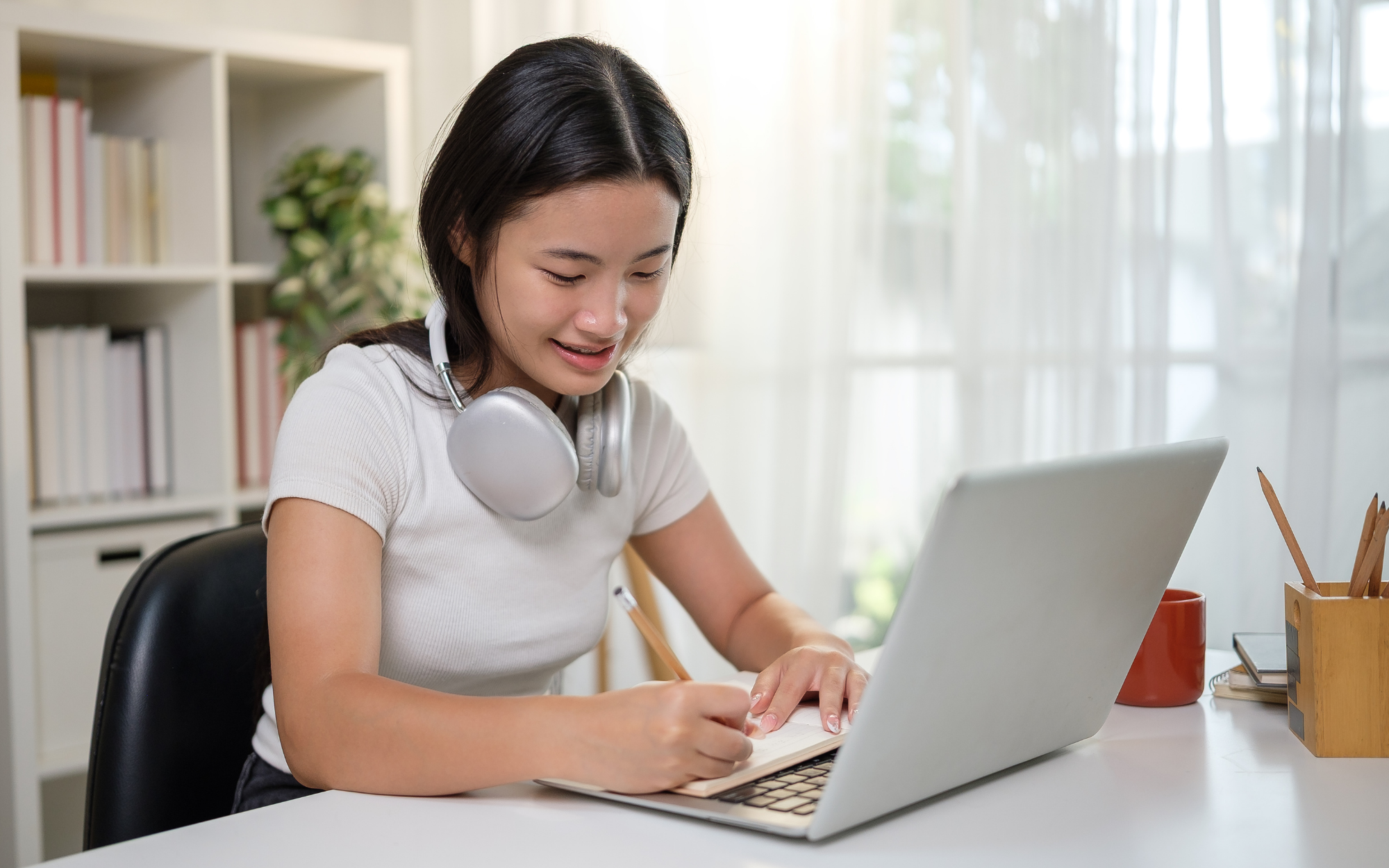 High school student smiling during online learning while receiving personalized academic support.<br />

