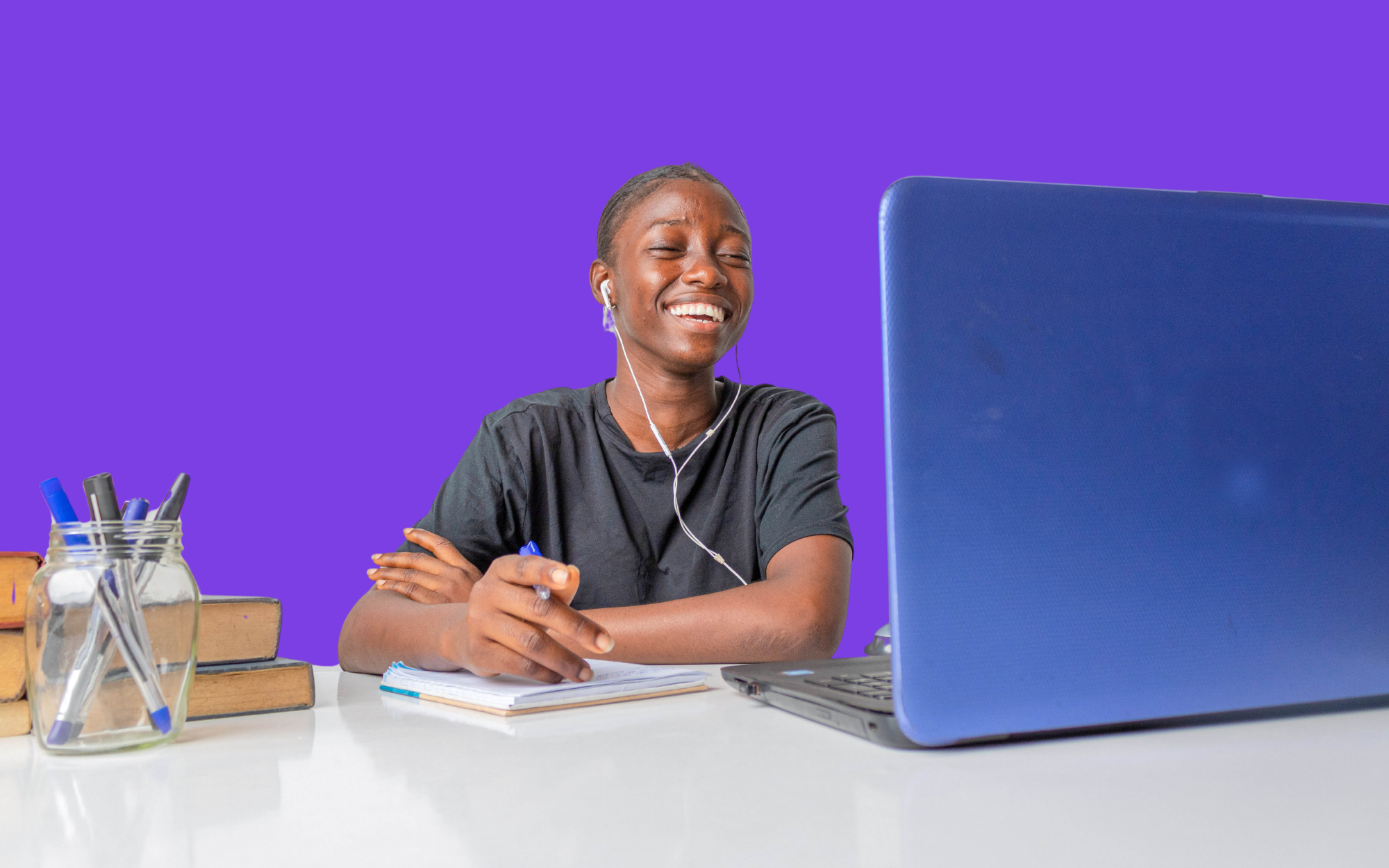 Student smiling during a live online class, showing connection and community in a virtual school environment.