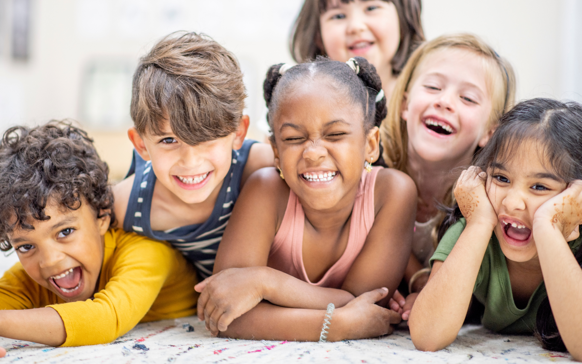 Group of children smiling and laughing together, representing socialization and friendships for online school students at Falcon View Online Minnesota.