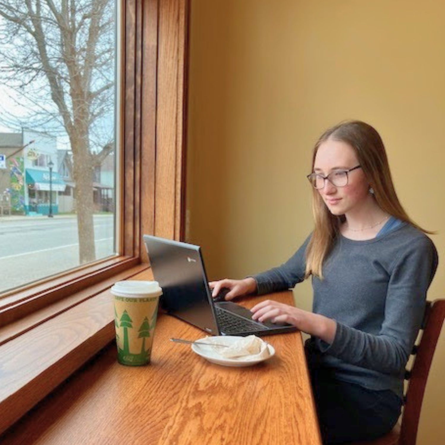 Minnesota student standing near a school bus while exploring alternative school options and flexible online learning through Falcon View Online.