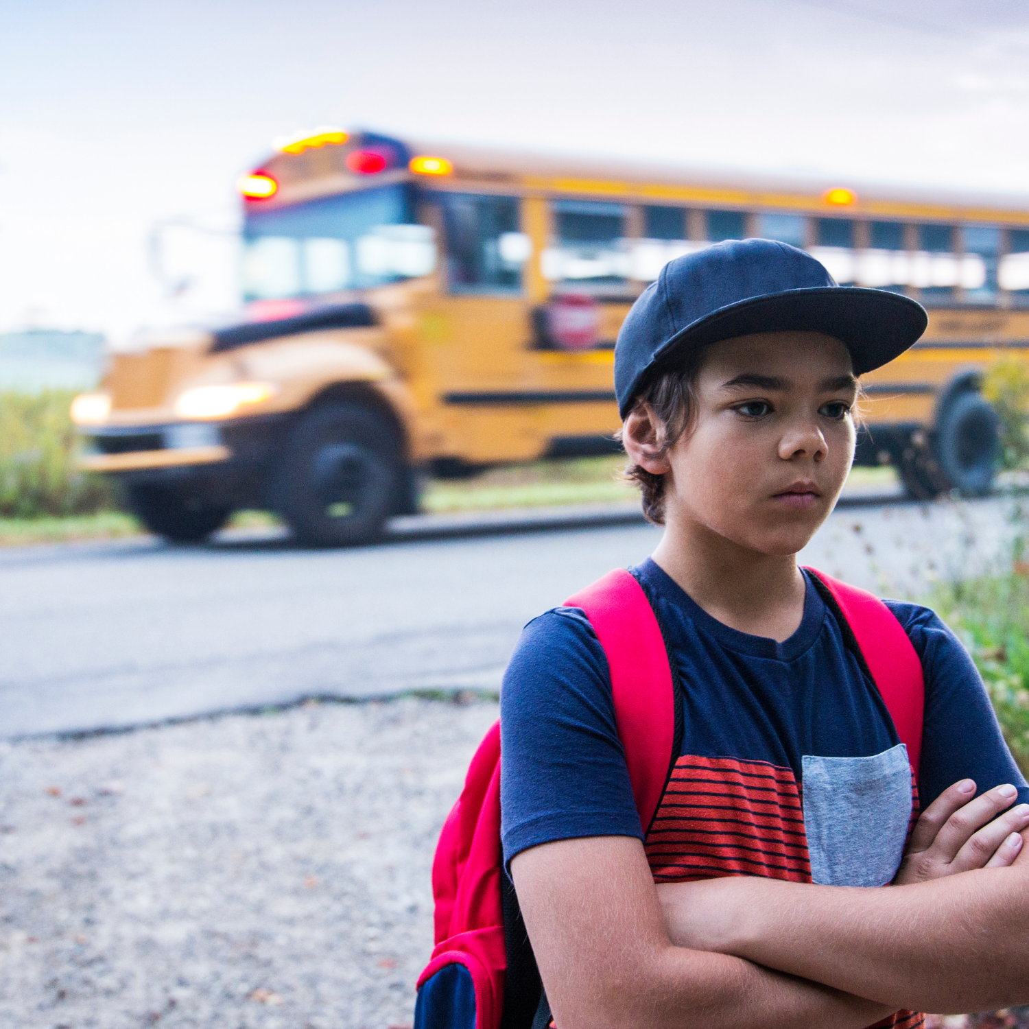 Minnesota student standing near a school bus while exploring alternative school options and flexible online learning through Falcon View Online.